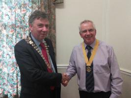 At his first meeting as President David McLuckie presents Senior Vice President Ian Gaston with his sash and badge for the year.